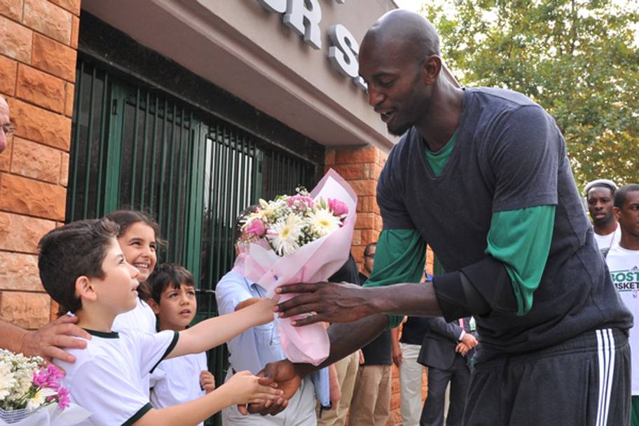 Kevin Garnett dei Boston Celtics riceve un mazzo di fiori da un piccolo fan a Istanbul